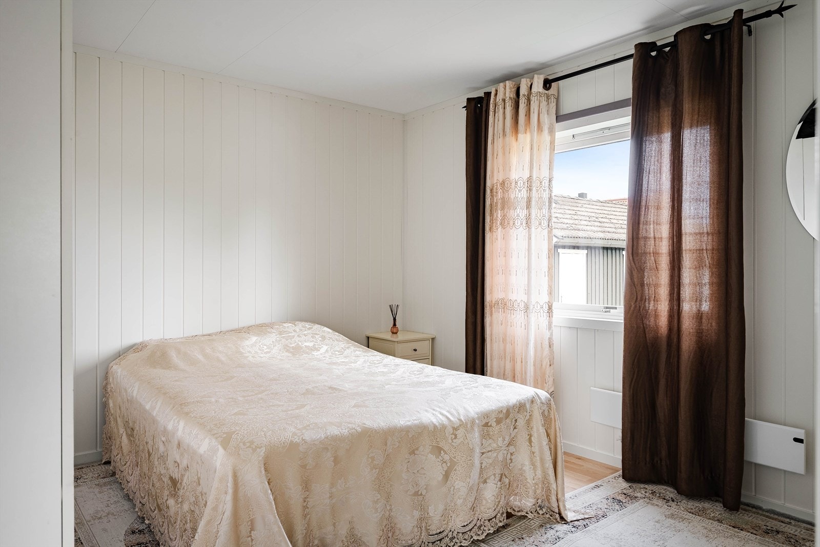 Lyst og hyggelig hovedsoverom i 1. etasje. Soverommet har laminat på gulv og lyse panelplater på veggene. Galleribilde