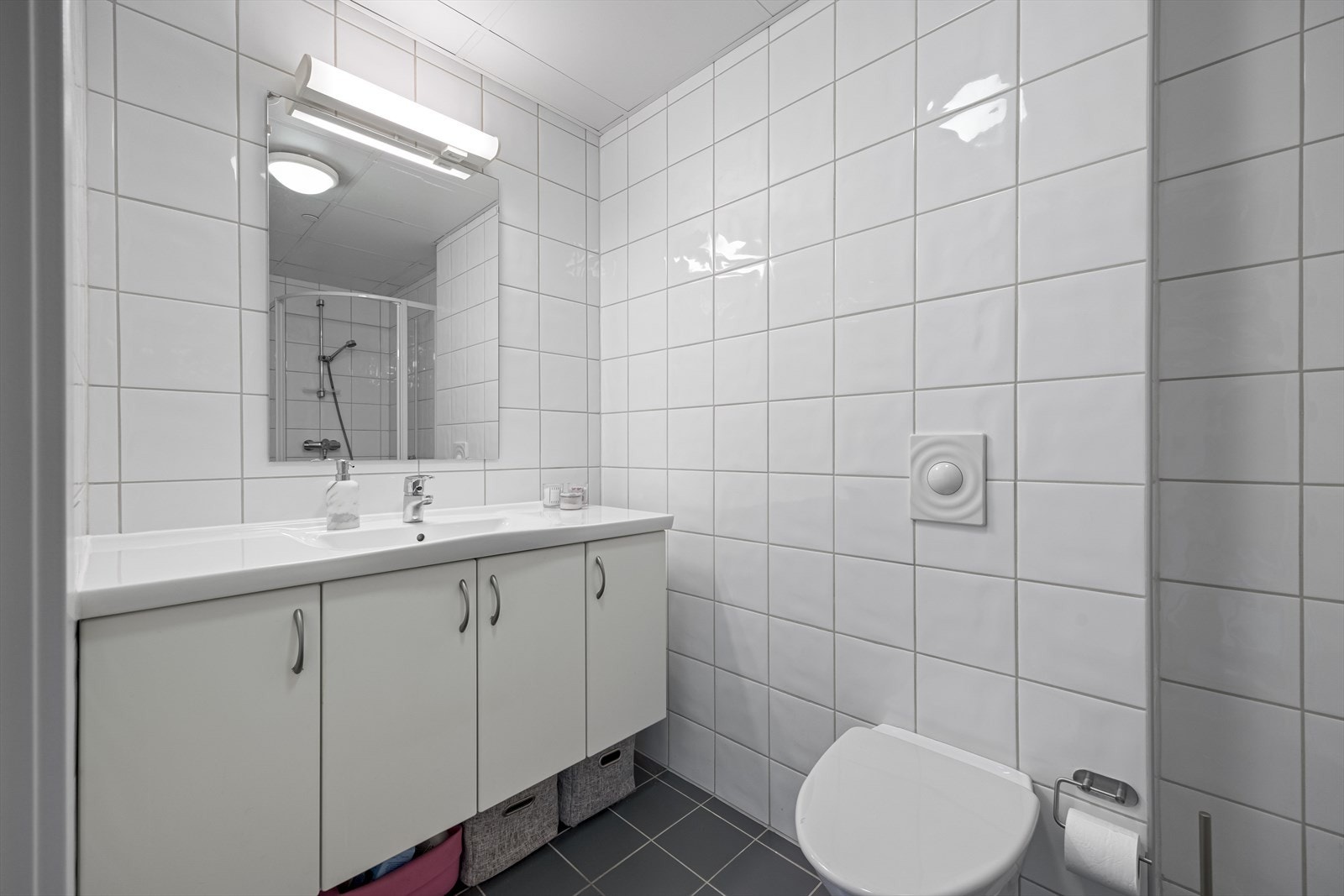 Bred servantinnredning på bad i hvit, slett utførelse. Galleribilde