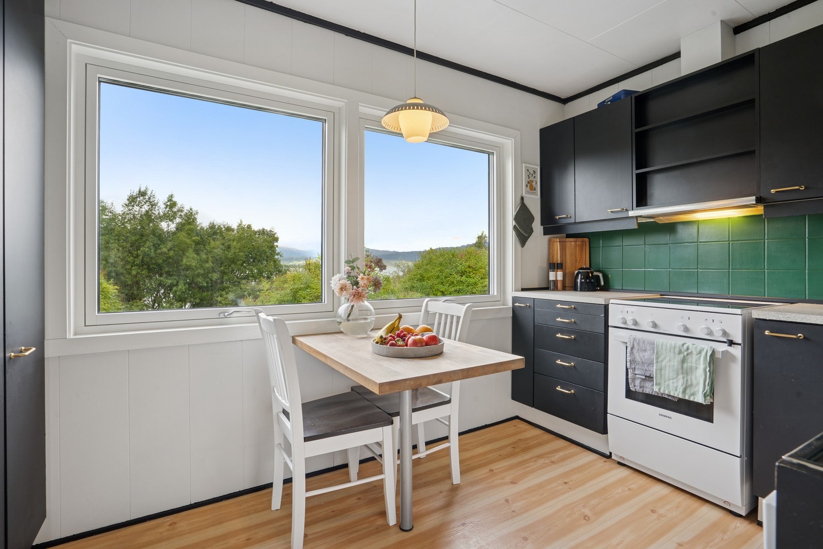 Kjøkkenet har store vinduer som slipper inn mye naturlig lys Galleribilde