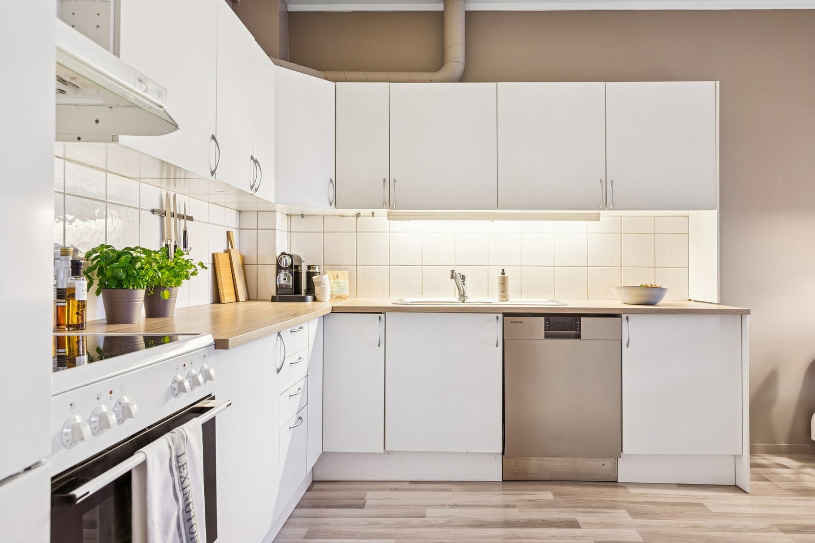 Fra entréen åpner boligen seg videre inn mot stue og kjøkken. Galleribilde