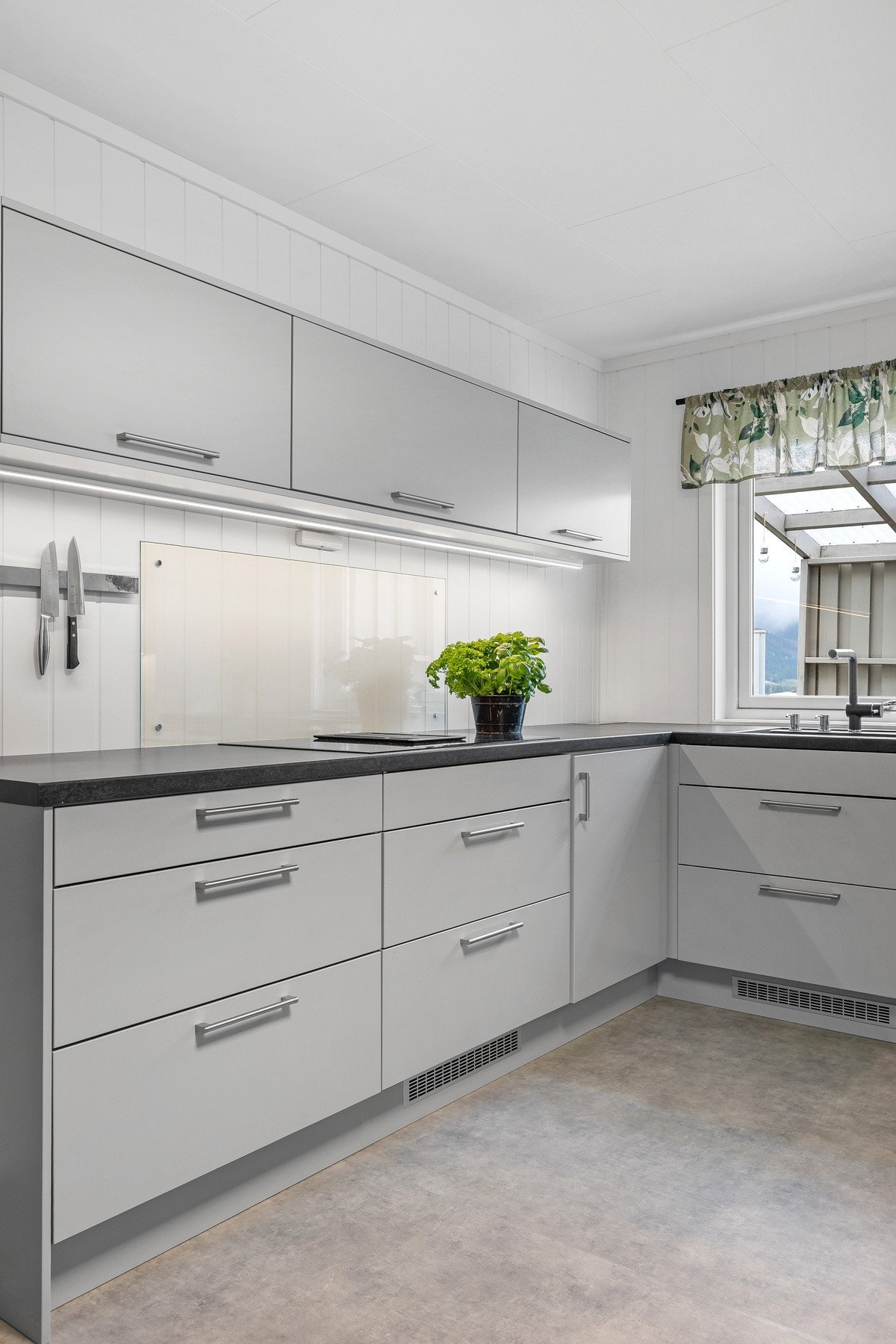 Kjøkkenet fremstår som moderne og innbydende. Innredningen har glatte, grå fronter som gir et stilrent og tidløst uttrykk. Galleribilde