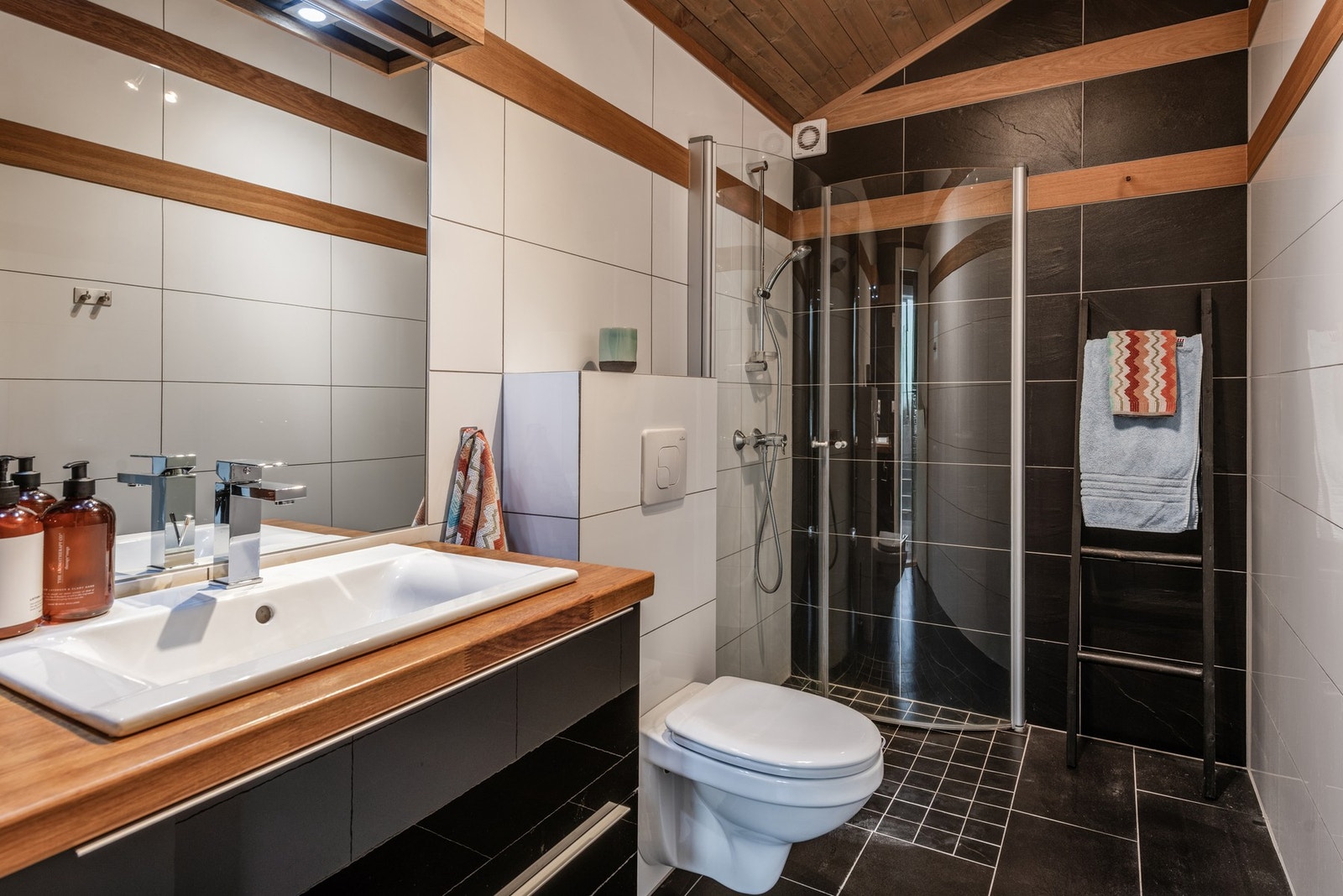 Badet holder høy standard og har flislagte gulv med termostatstyrt gulvvarme, flislagte vegger med detalsjer i trepanel og himling i tre. Galleribilde