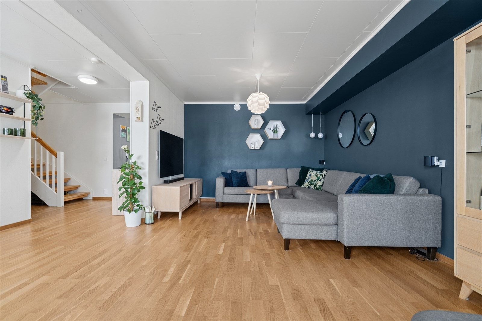 Stuen er utført med et pent gulv, hvitmalte overflater og kontrastvegger malt i en mørk blåtone Galleribilde