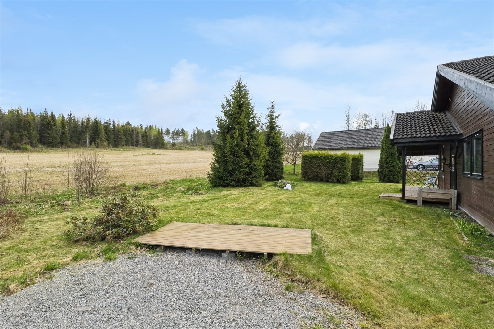 Stor fin hage med terrasseplatting ved utgang og i hagen Galleribilde