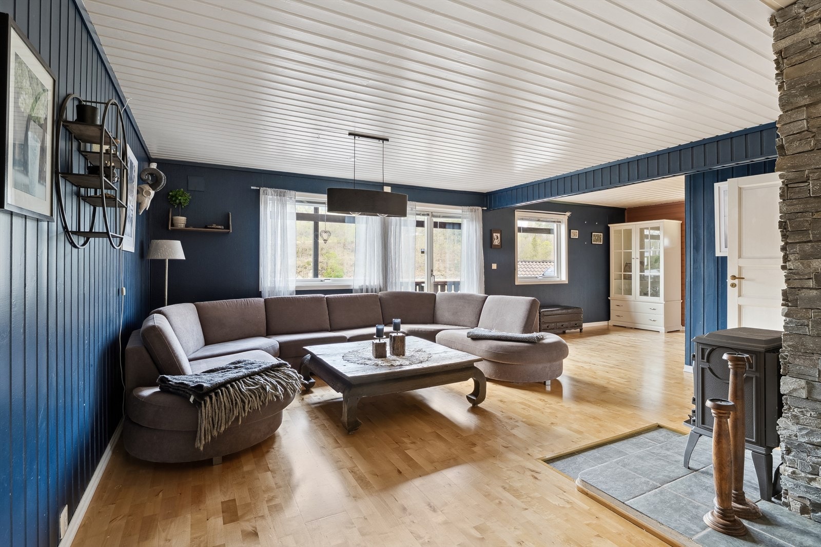 Stue med parkett og malt panel og malt tapet. Galleribilde