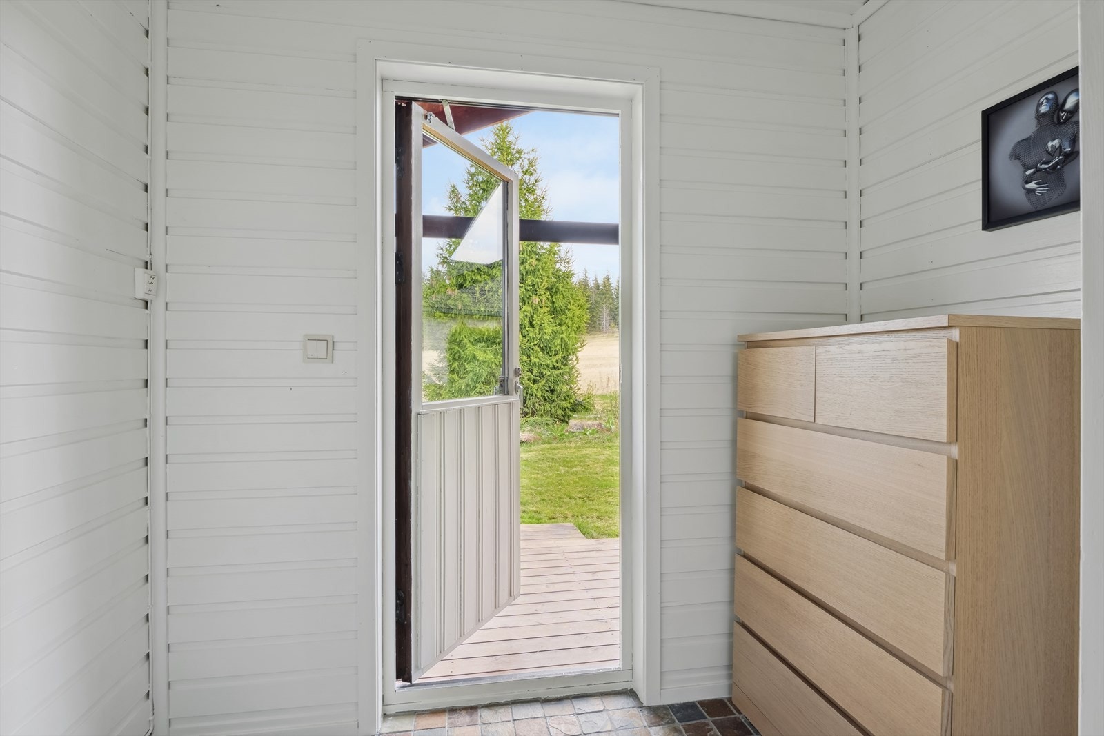 Gang oppe bak med utgang til terraseplatting og hage. Galleribilde