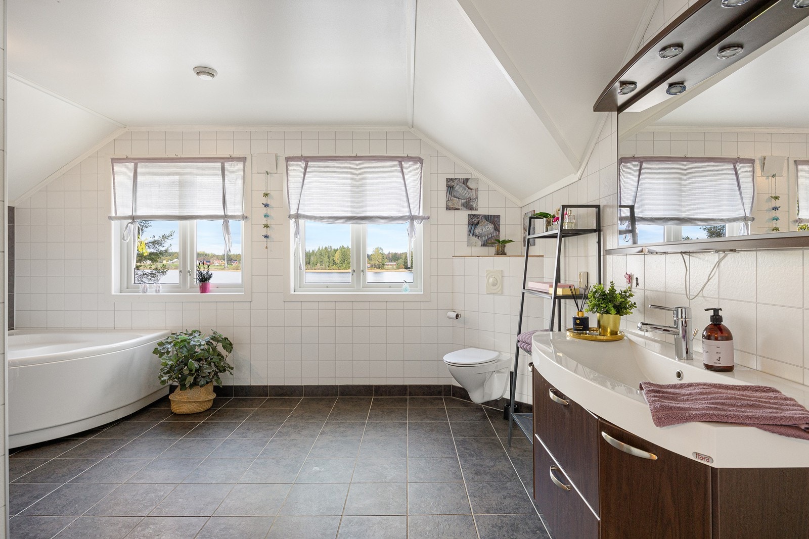 Ved soverommene i andre etasje er det et stort, pent og velholdt bad med hvite fliser og grå våtromsplater på veggene, samt koksgrå fliser på gulv med vannbåren gulvvarm. Galleribilde