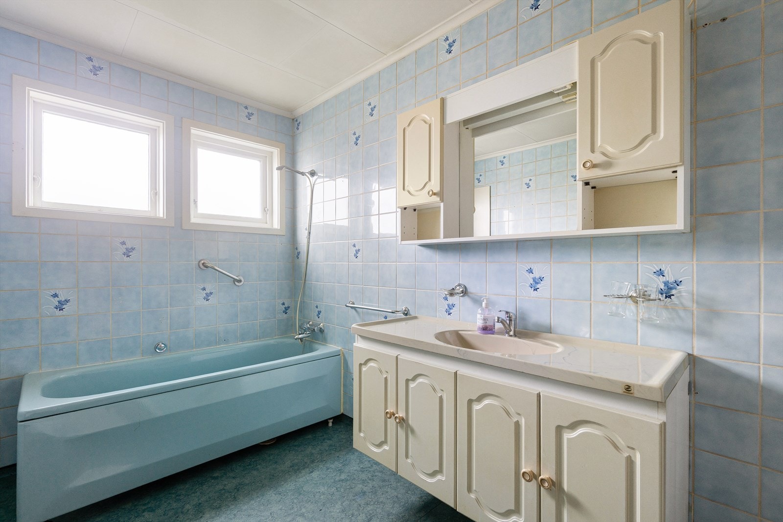 Flislagt baderom, badekar og praktisk innredning. Vinduer som gir naturlig lysinnslipp. Galleribilde