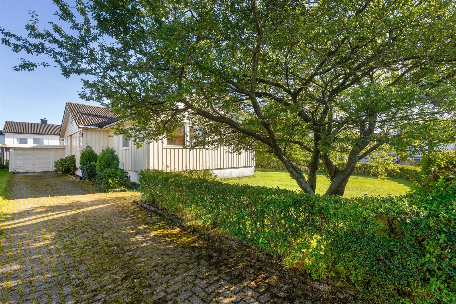 Sjarmerende enebolig med frodig hage, flott innkjørsel og garasje. Rolig nabolag, perfekt for familier. Solrik og romslig tomt. Galleribilde