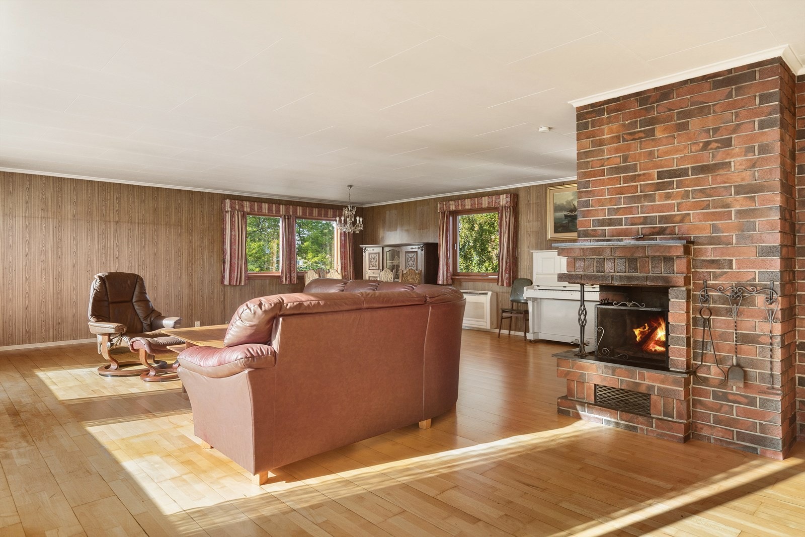 Lys og romslig stue med peis, perfekt for avslapning og sosiale sammenkomster. Store vinduer gir flott utsikt og naturlig lys. Galleribilde