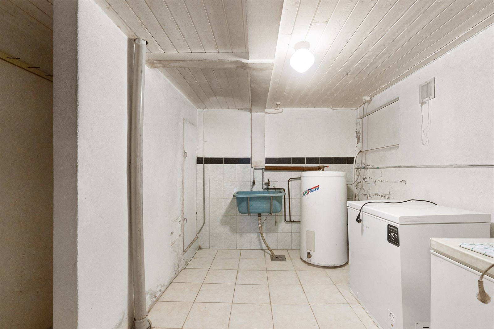 Praktisk vaskeromsløsning med varmtvannsbereder og fryseboks, ideell for oppbevaring og hverdagsbruk. Galleribilde