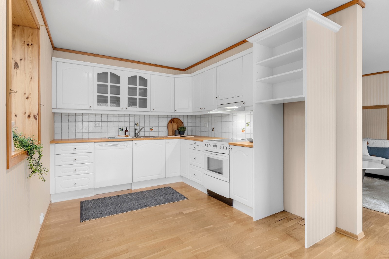 Pen, hvit kjøkkeninnredning med komfyr og oppvaskmaskin. Galleribilde