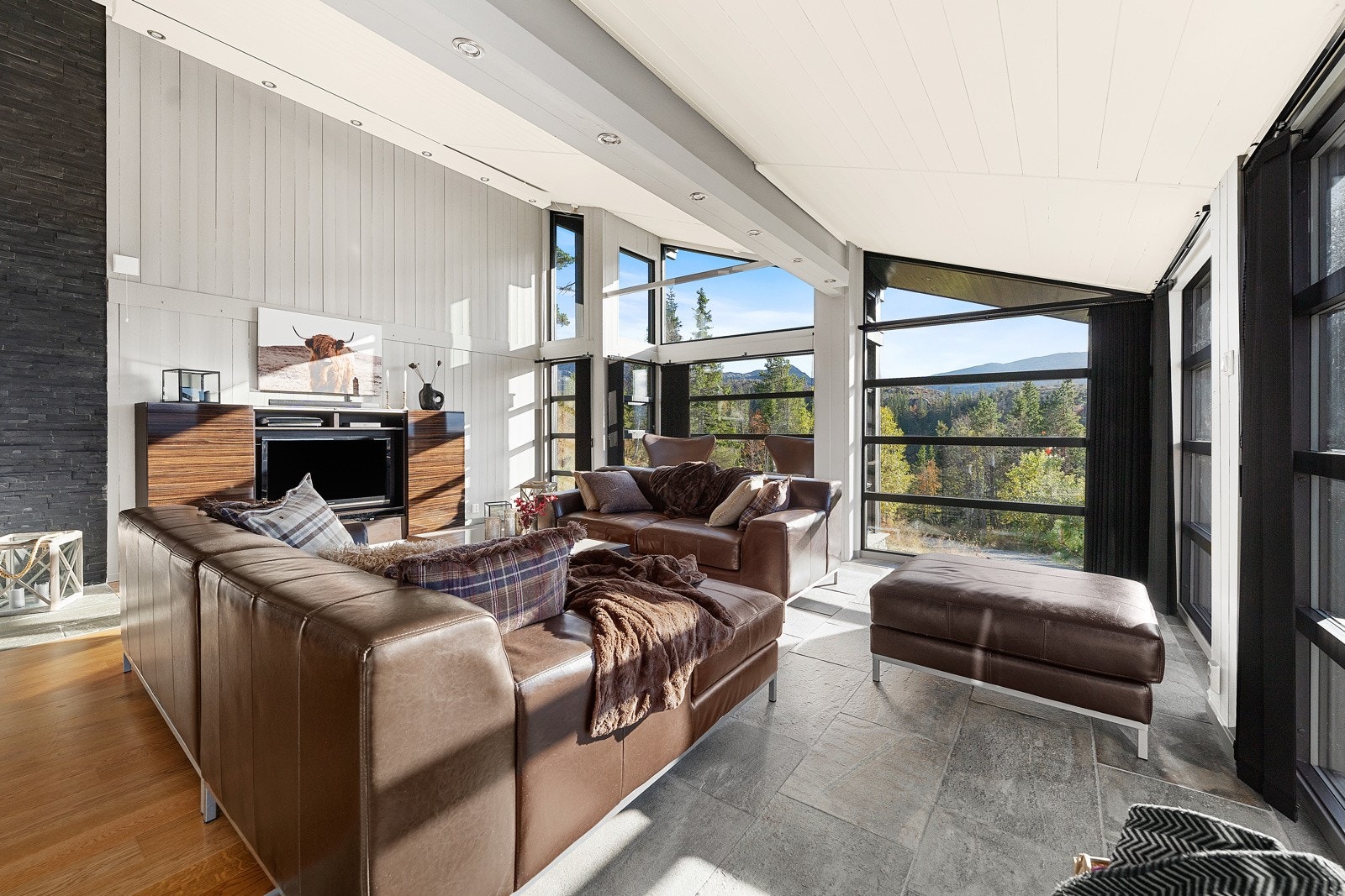 Rommet har store vindusflater fra gulv til tak som bringer den spektakulære utsikten rett inn i oppholdssonene Galleribilde