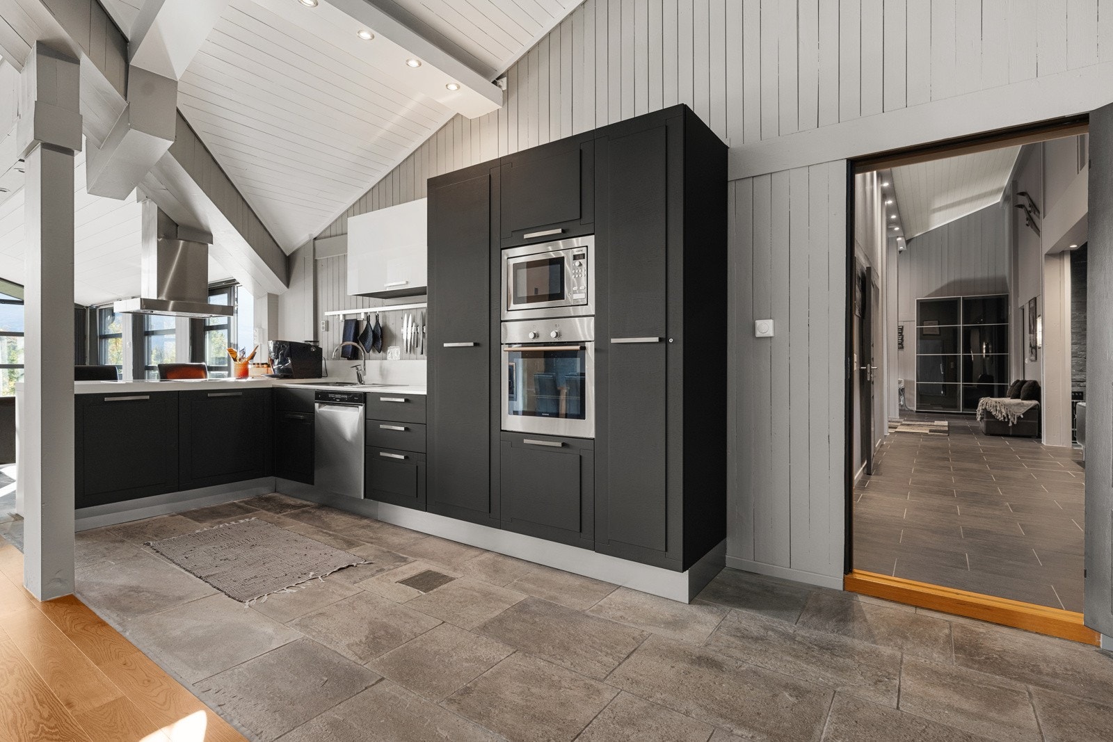 Moderne kjøkken med fronter i eik i vinkelform med barløsning mot stue Galleribilde