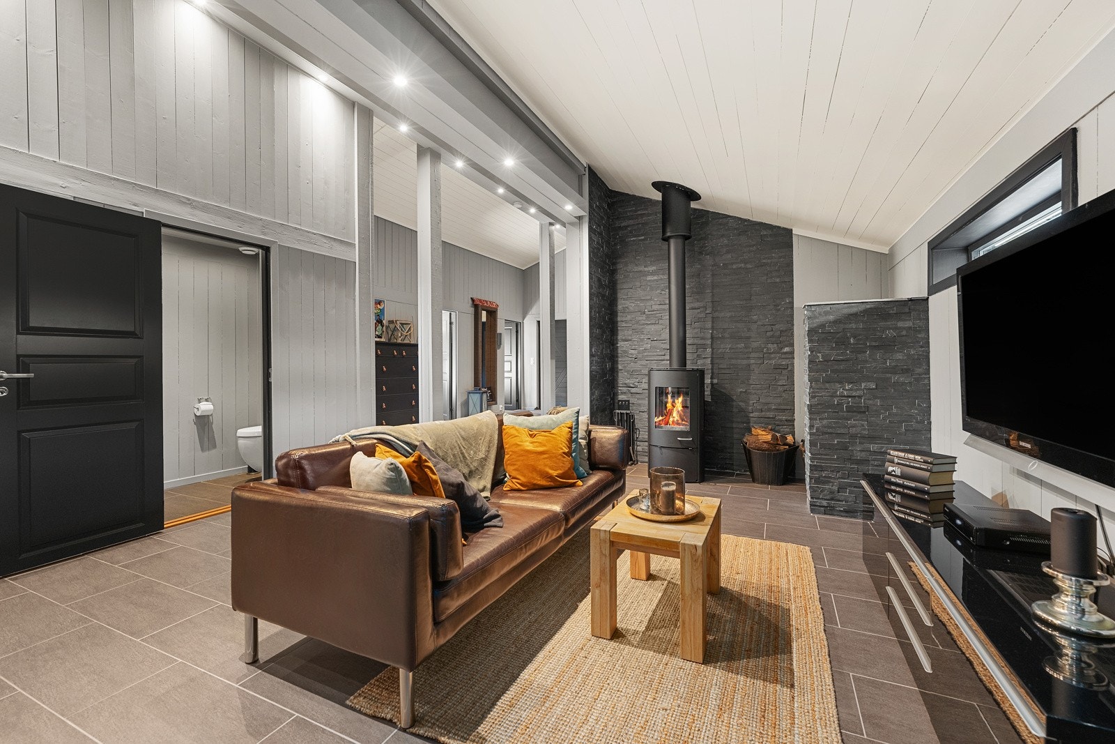 Rommet egner seg perfekt som en ekstra stue for barn/ungdom, eller for å trekke seg tilbake med en god bok. En moderne peisovn gir godt med varme Galleribilde