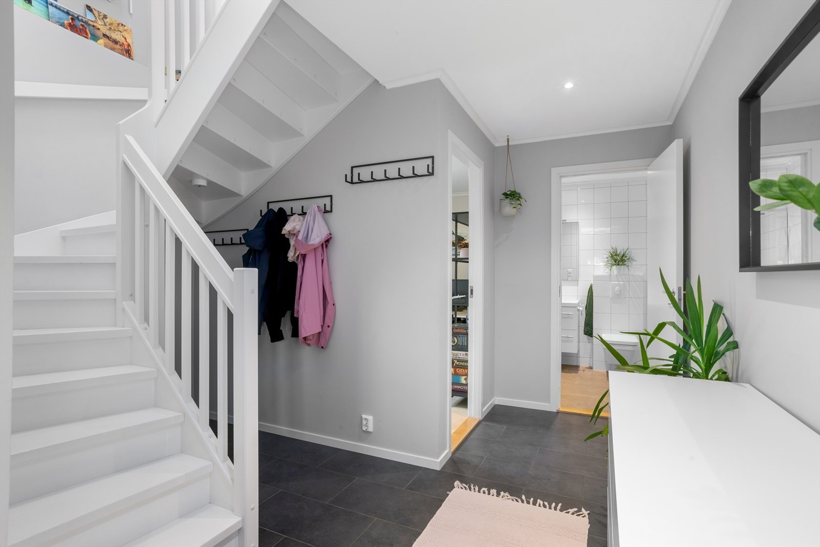 Gulvflisene med underliggende varmekabler gir et solid preg, mens den vide løsningen i hallen skaper en lys og luftig atmosfære. Rikelig med integrerte downlights i taket sørger for god belysning. Galleribilde