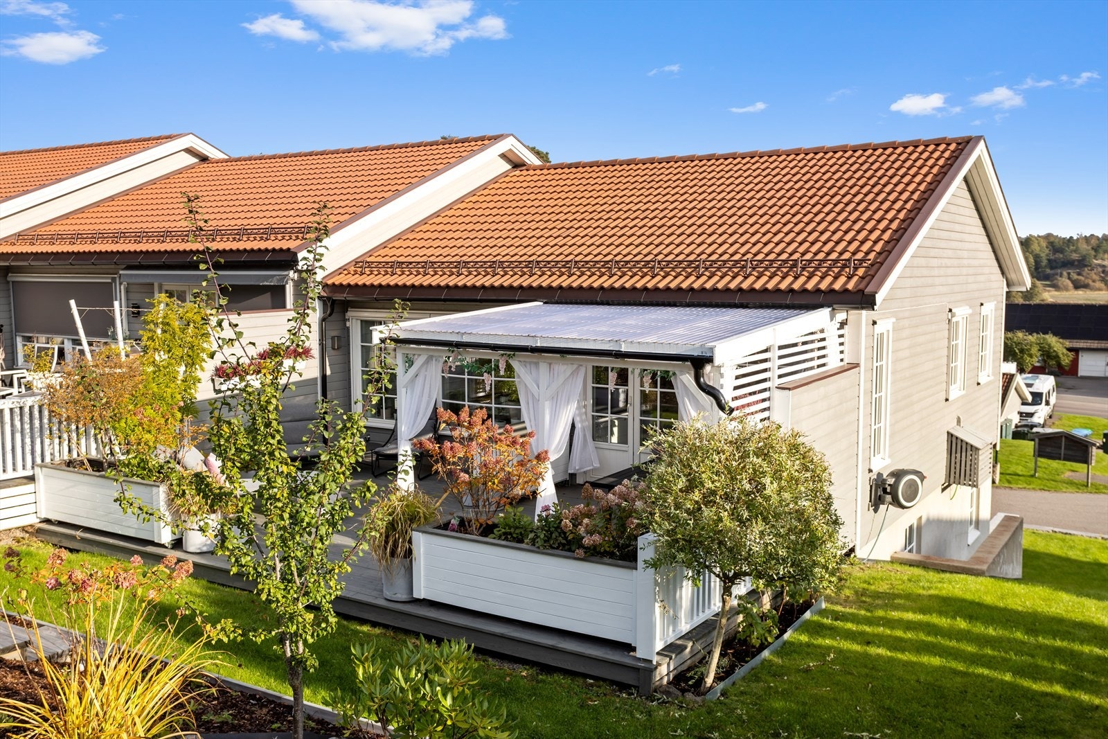 Denne romslige og avskjermede uteplassen blir som et herlig "utendørseldorado" hvor man kan nyte privatliv på et område som i sommerhalvåret oppleves som "ekstra stuer". Galleribilde