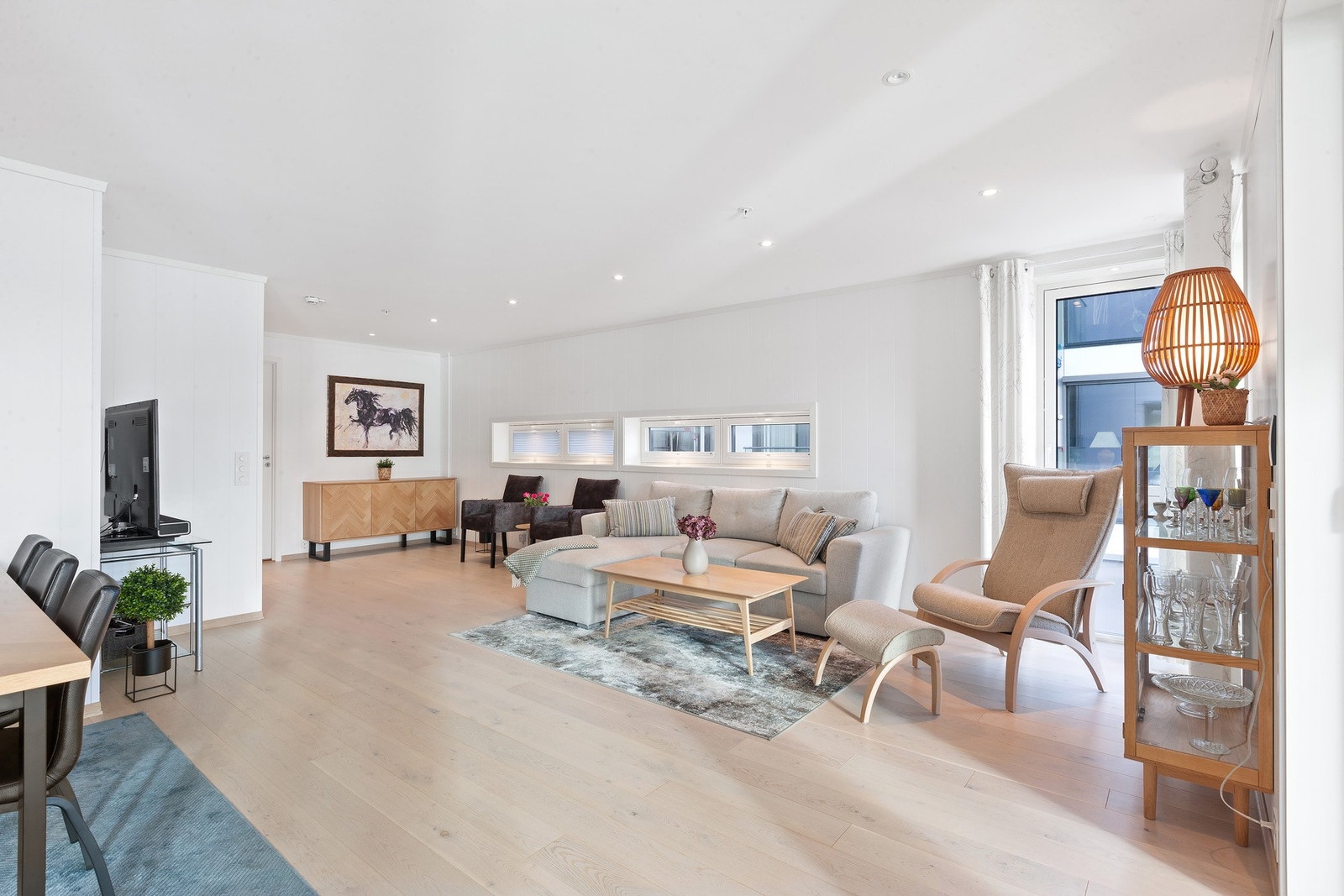 Stue med spotter i tak og i vinduer. Plisse-gardiner i de små liggende vinduene. Galleribilde