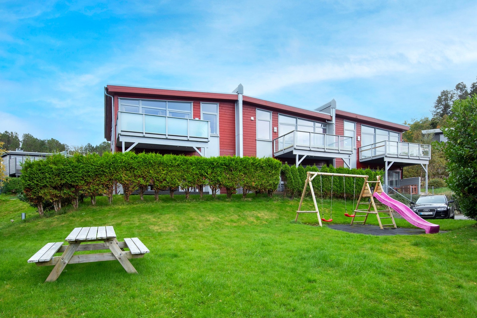 Eiet tomt som har opparbeidede uteområder med asfalt, beplanting, plen, m.m. Galleribilde