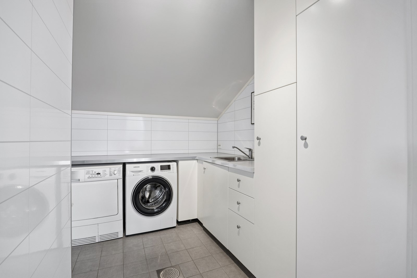 Vaskerom i andre etasje fra 2015 med flislagt gulv med elektrisk gulvvarme. Veggene har baderomsplater og taket er malt. Rommet er utstyrt med innredning med nedfelt servant og opplegg for vaskemaskin. Ventilasjon via balansert anlegg. Galleribilde