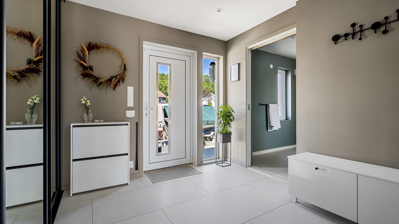 Romslig, flislagt gang med adkomst til bad/ vaskerom Galleribilde