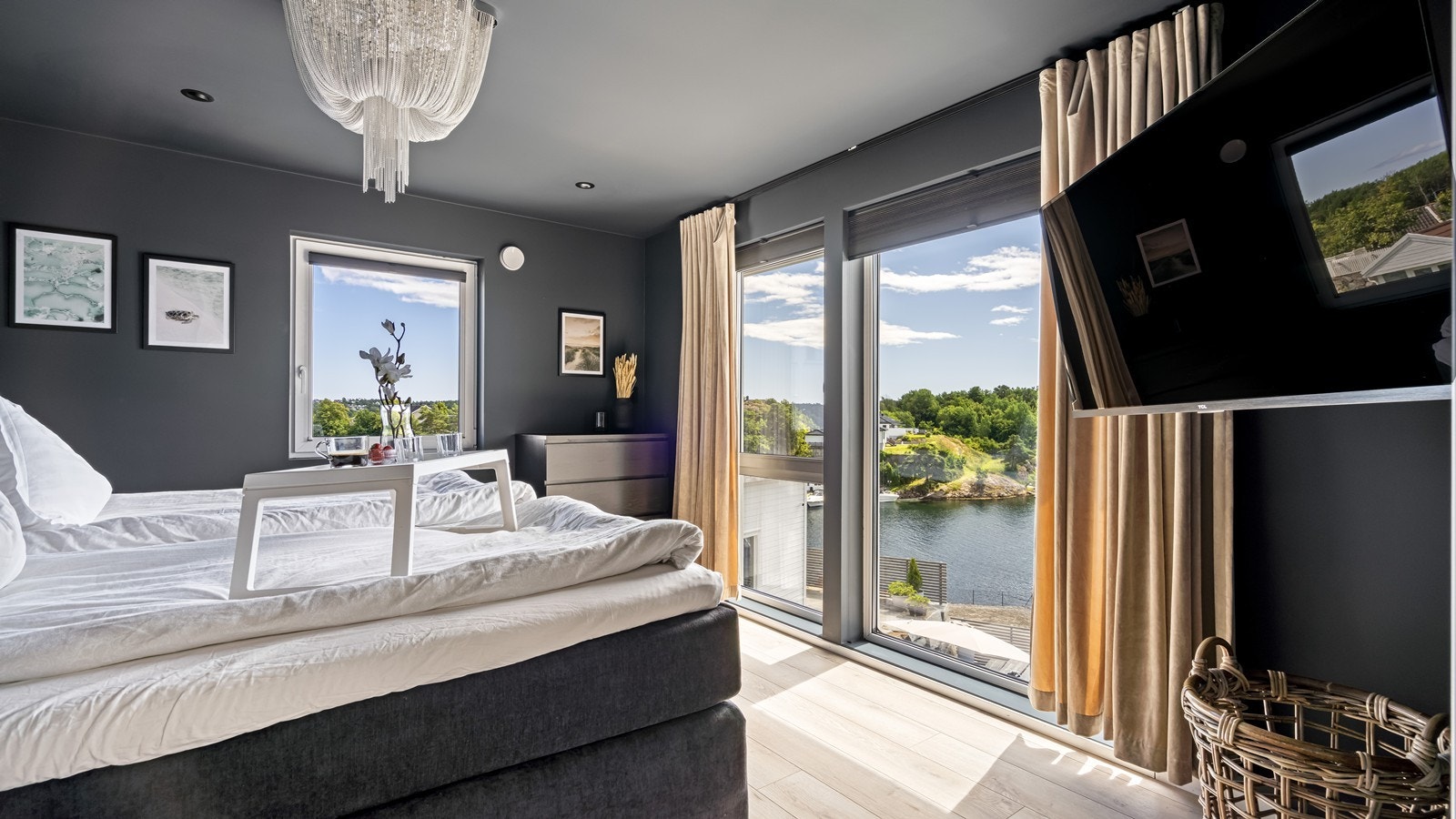 Stort soverom med nydelig utsikt fra vindu som går fra gulv til tak Galleribilde