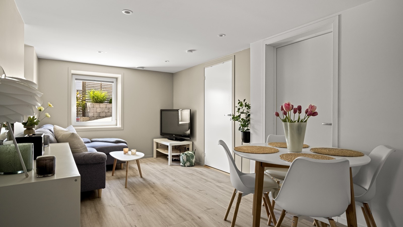 God plass til sofa, bord og tv med tilhørende møblement Galleribilde