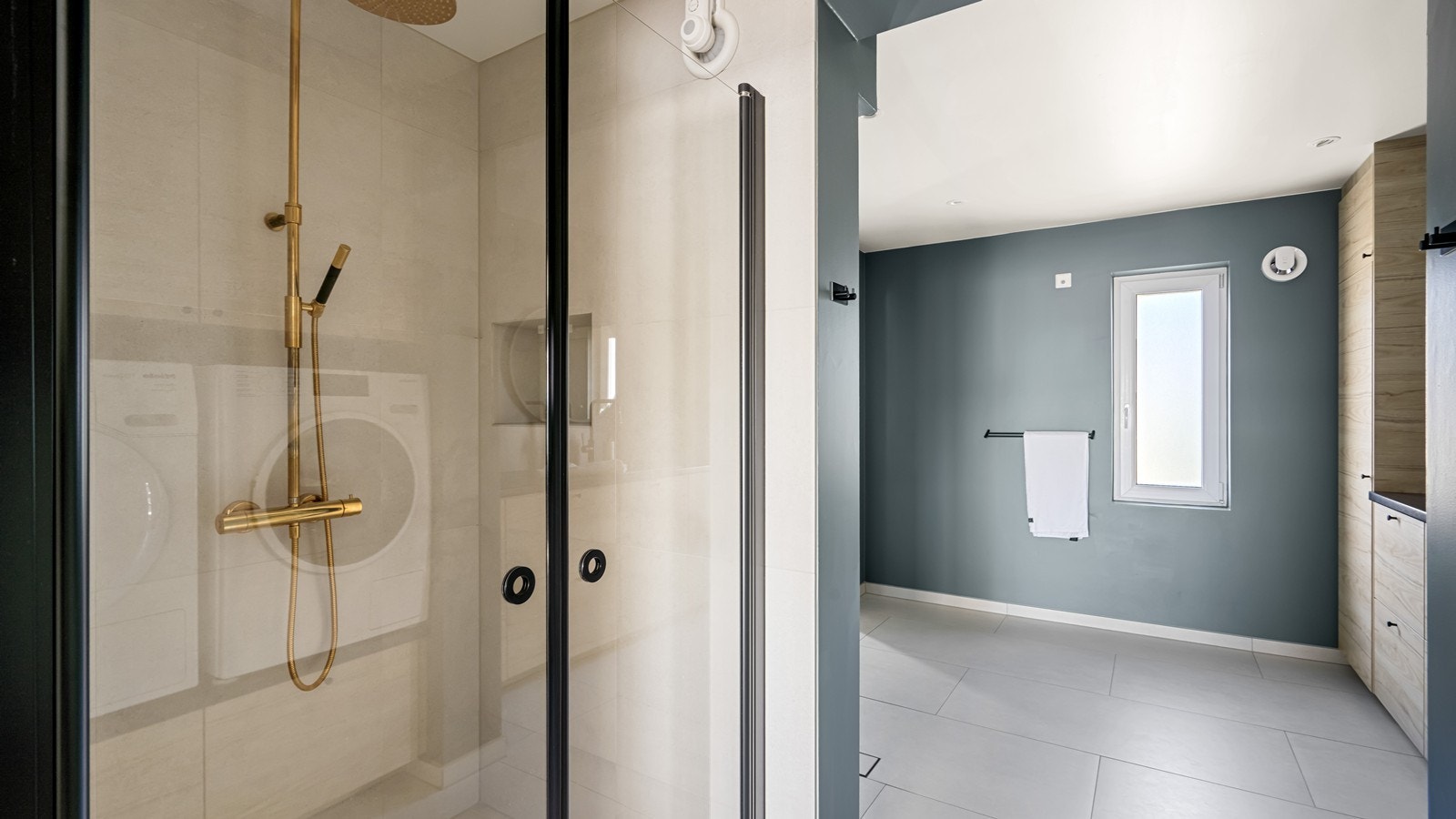 Badet har en praktisk plassering i boligen og er en kombinasjon mellom vaskerom og bad. Tapwell dusjarmatur og servantbatteri. Galleribilde