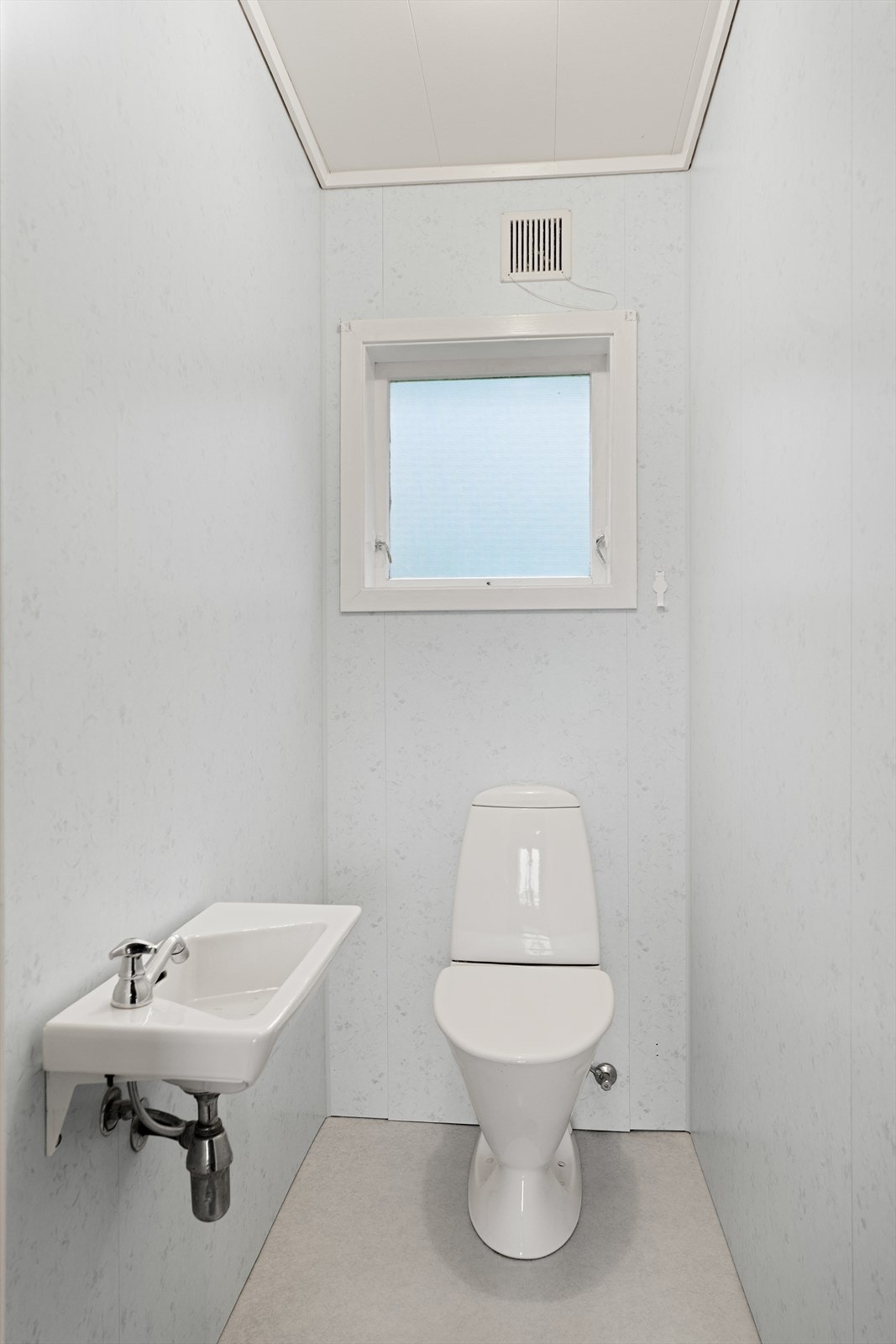 Toalettrom med badersomplater på vegger og belegg på gulv Galleribilde