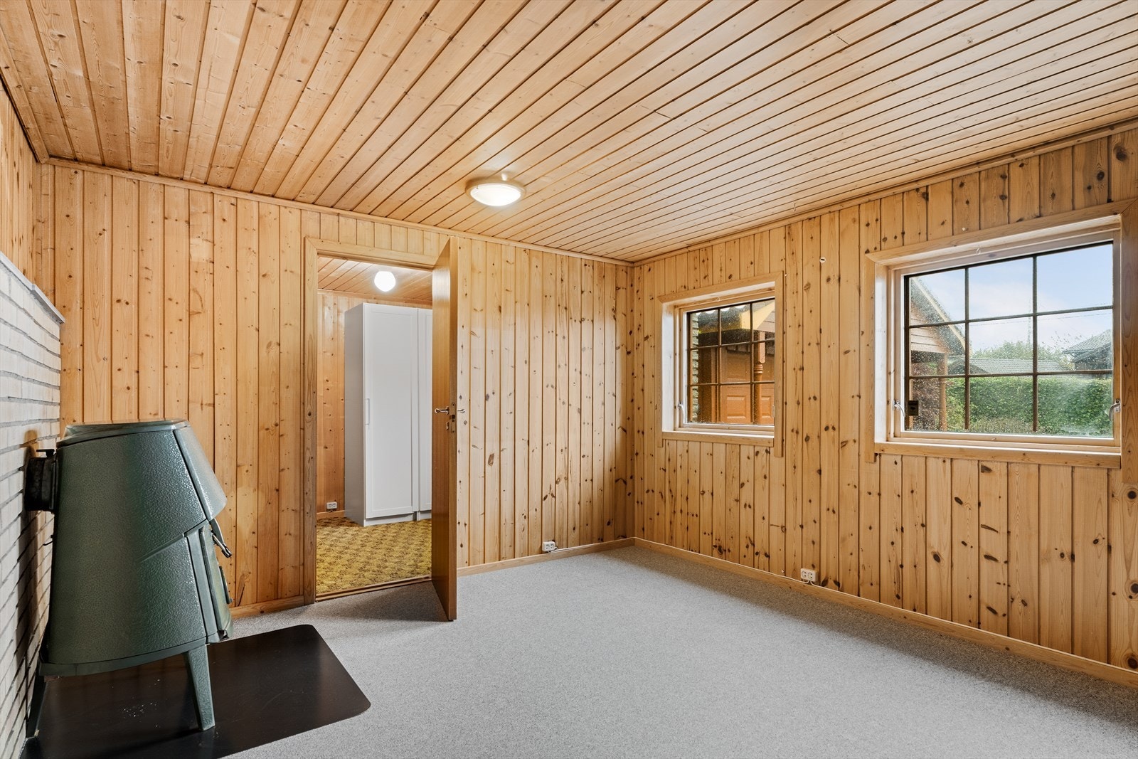 Koselig kjellerstue med teppe på gulv og panel på tak/vegger (ikke godkjent som oppholdsrom) Galleribilde