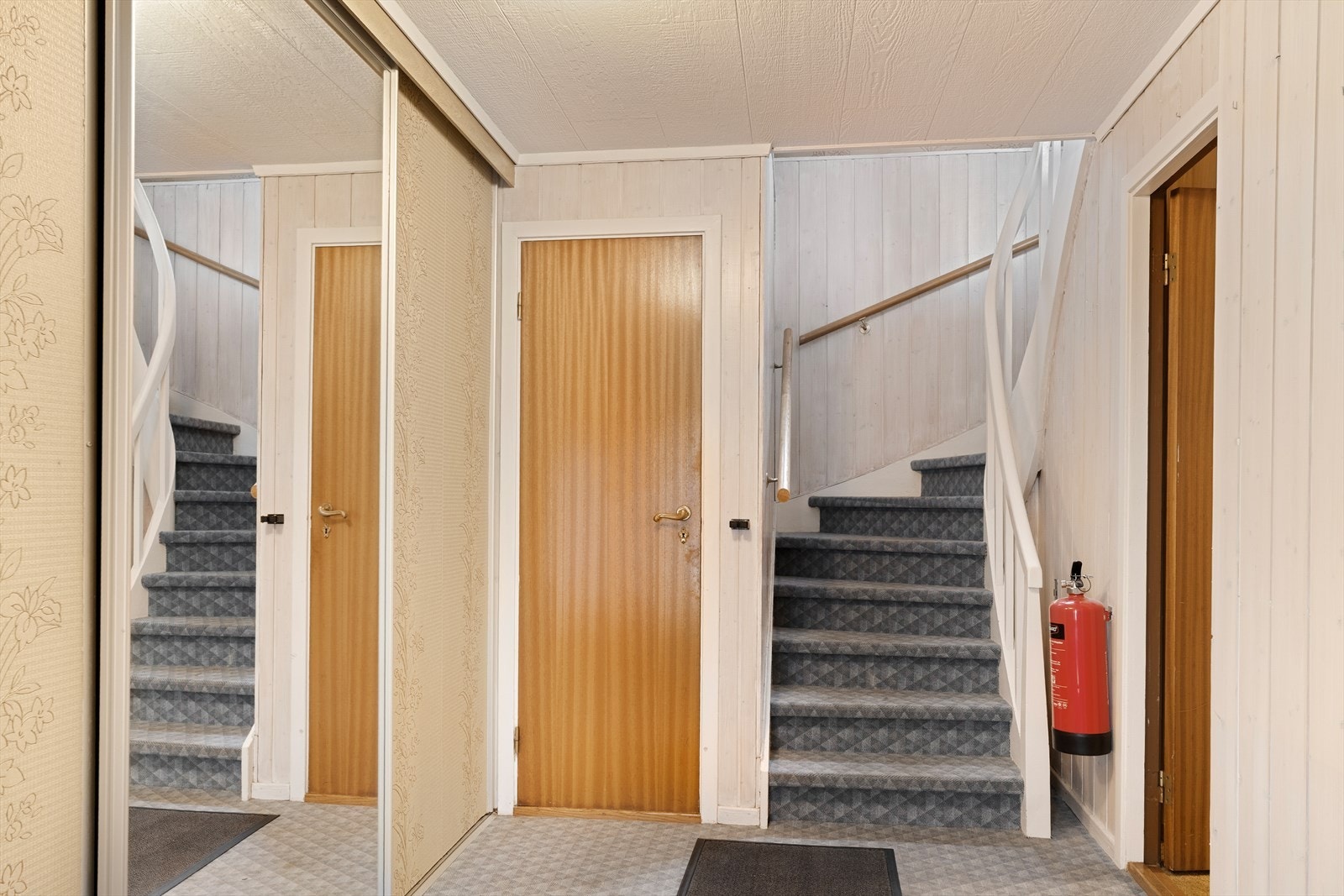 Stor hall i underetasjen med romslig skyvedørsgarderobe Galleribilde