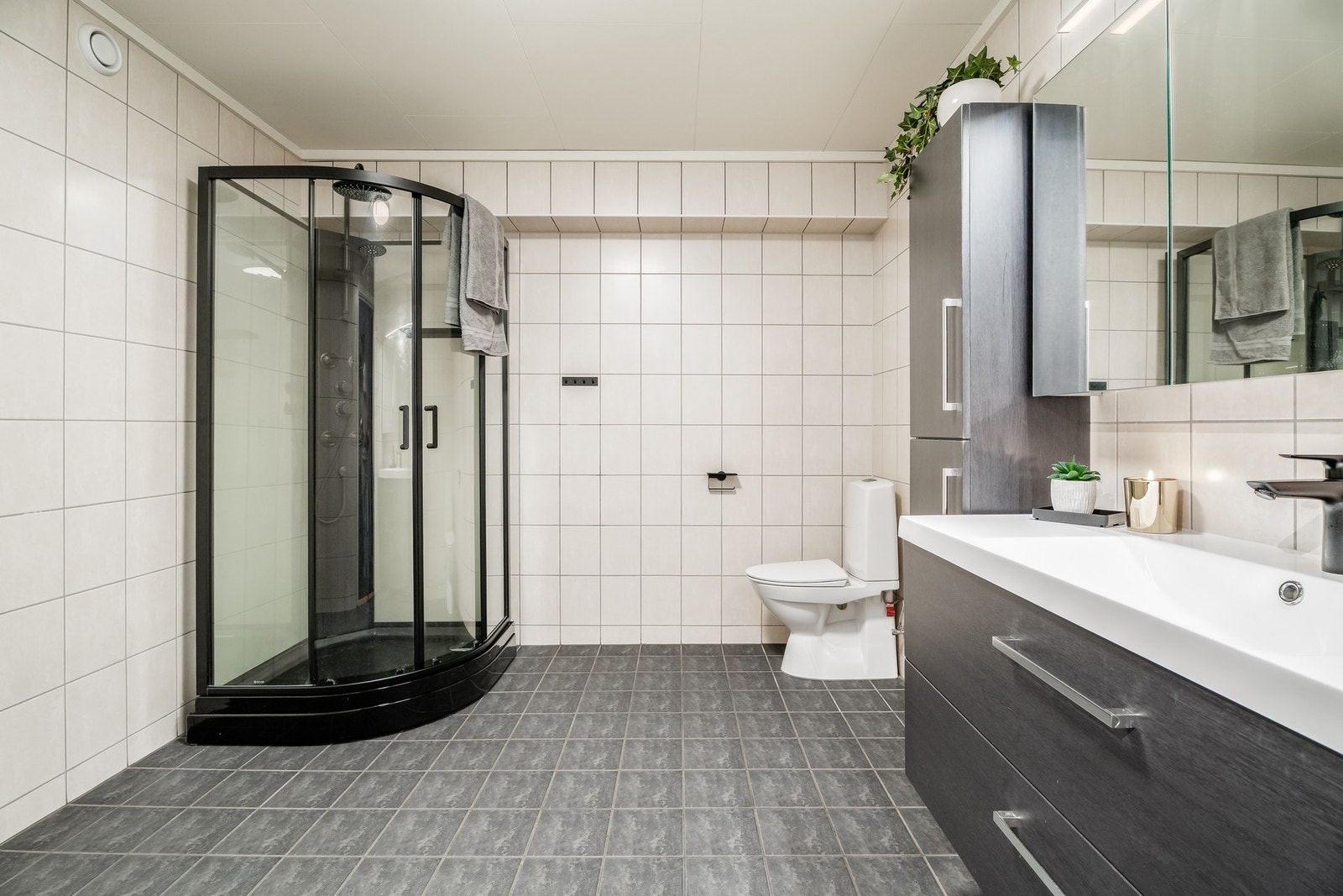 Pent og romslig flislagt bad med varmekabler i gulv. Dusjkabinett nytt i 2024 Galleribilde