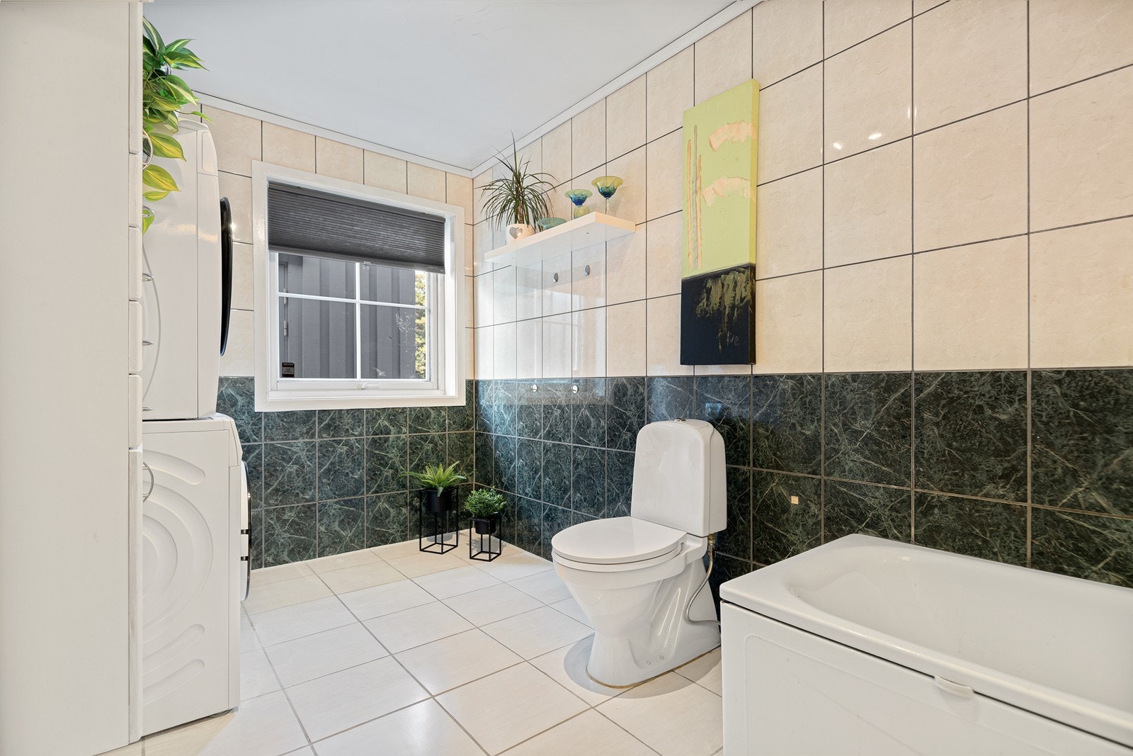 Badet i hovedetasjen er flislagt og er av god størrelse Galleribilde