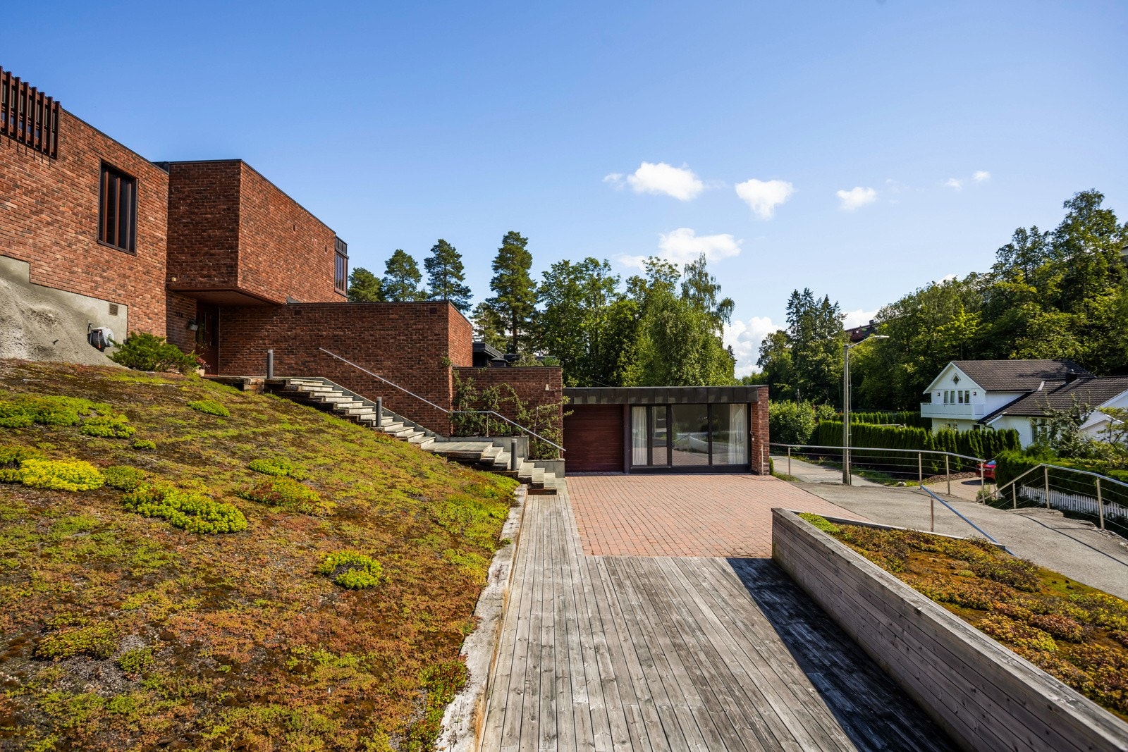 Uteområdene rundt boligen er tilrettelagt for å være mest mulig vedlikeholdsfritt og lettstelt, med diverse murer, steinsatte områder og beplantning med Sedum som er tilnærmet vedlikeholdsfritt men samtidig gir vakre farger. Galleribilde