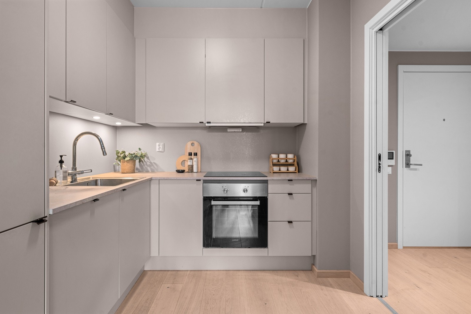 Kjøkkenet har slette fronter og rikelig med skap- og benkeplass Galleribilde