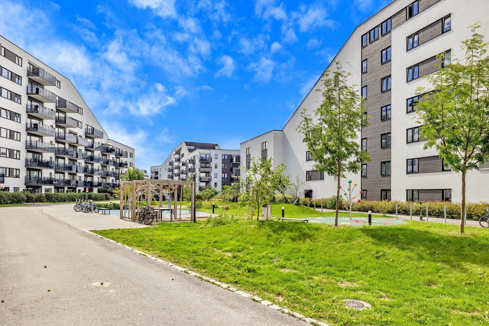 Felles indre gårdsrom har lekestativ, sittegrupper og felles grill, m.m. Galleribilde