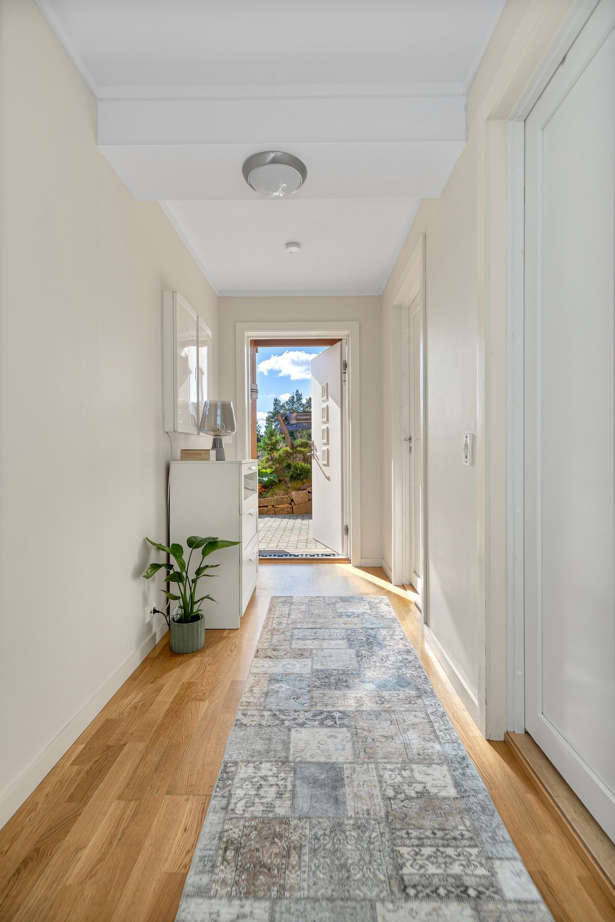 Leiligheten har en pen entré med lysmalte vegger og gyllent, trestavs parkettgulv. Galleribilde