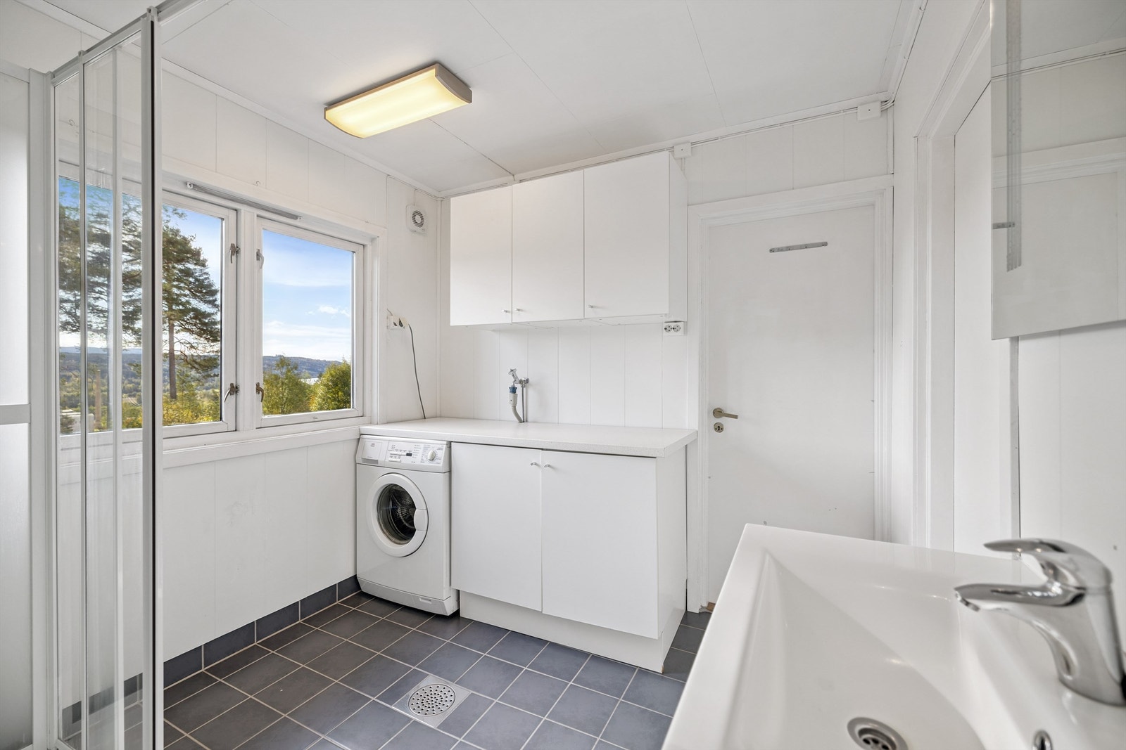 God størrelse på rommet, med plass til en egen vaskeromsdel med praktisk benkeplass og opplegg for vaskemaskin. Galleribilde