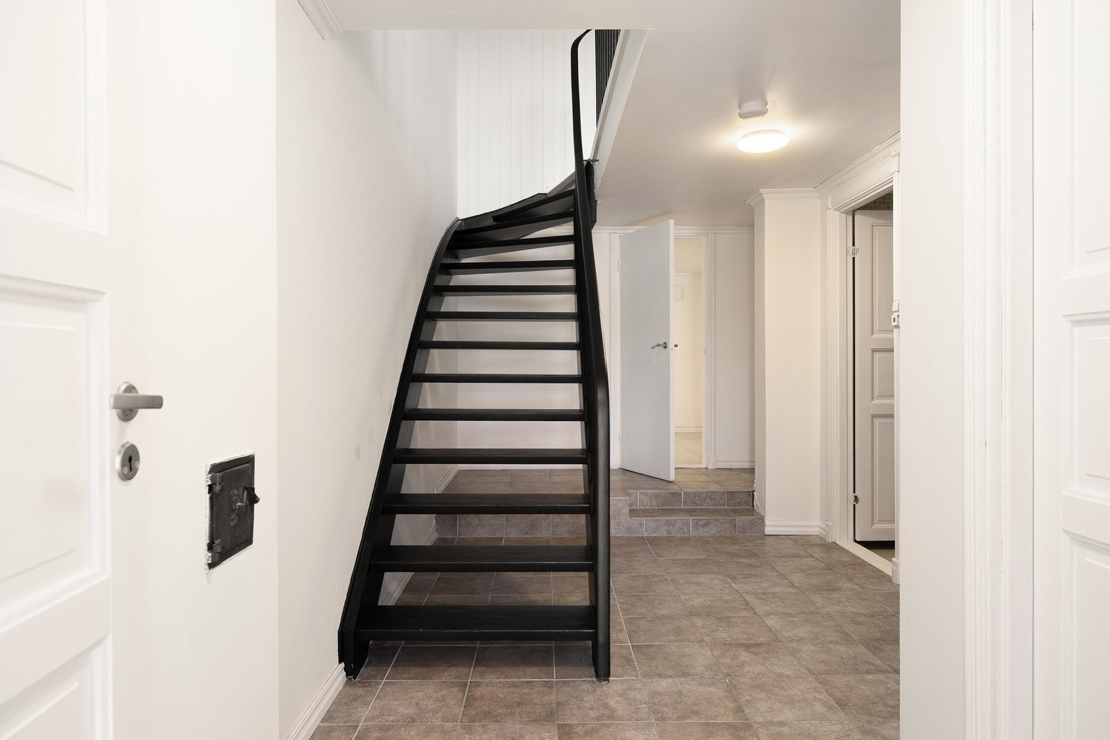 Sort trapp gir karakter til trapperommet. Fra gangen er det adgang til soverommet i 1. etasje, samt bad og bod. Galleribilde