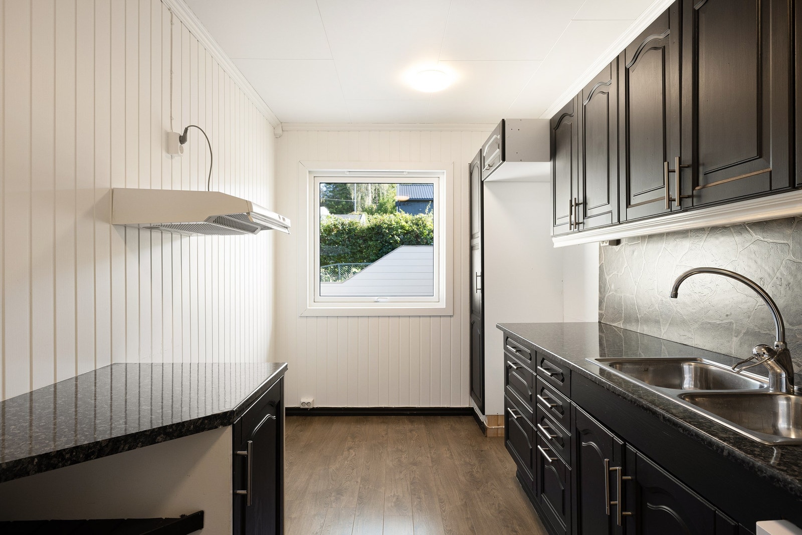 Sterke kontraster med mørke skap, og hvite overflater på vegg og i himling. Galleribilde