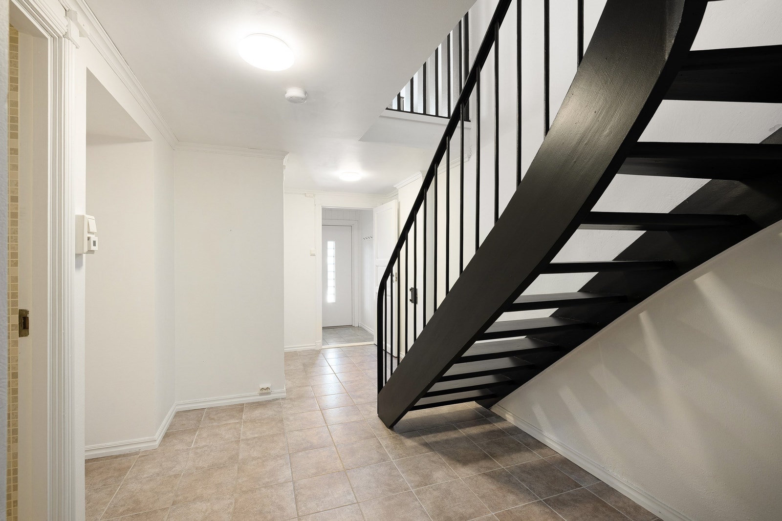 Entréen møter deg med lys, flislagt gulv og en markant trapp som blikkfang. Galleribilde