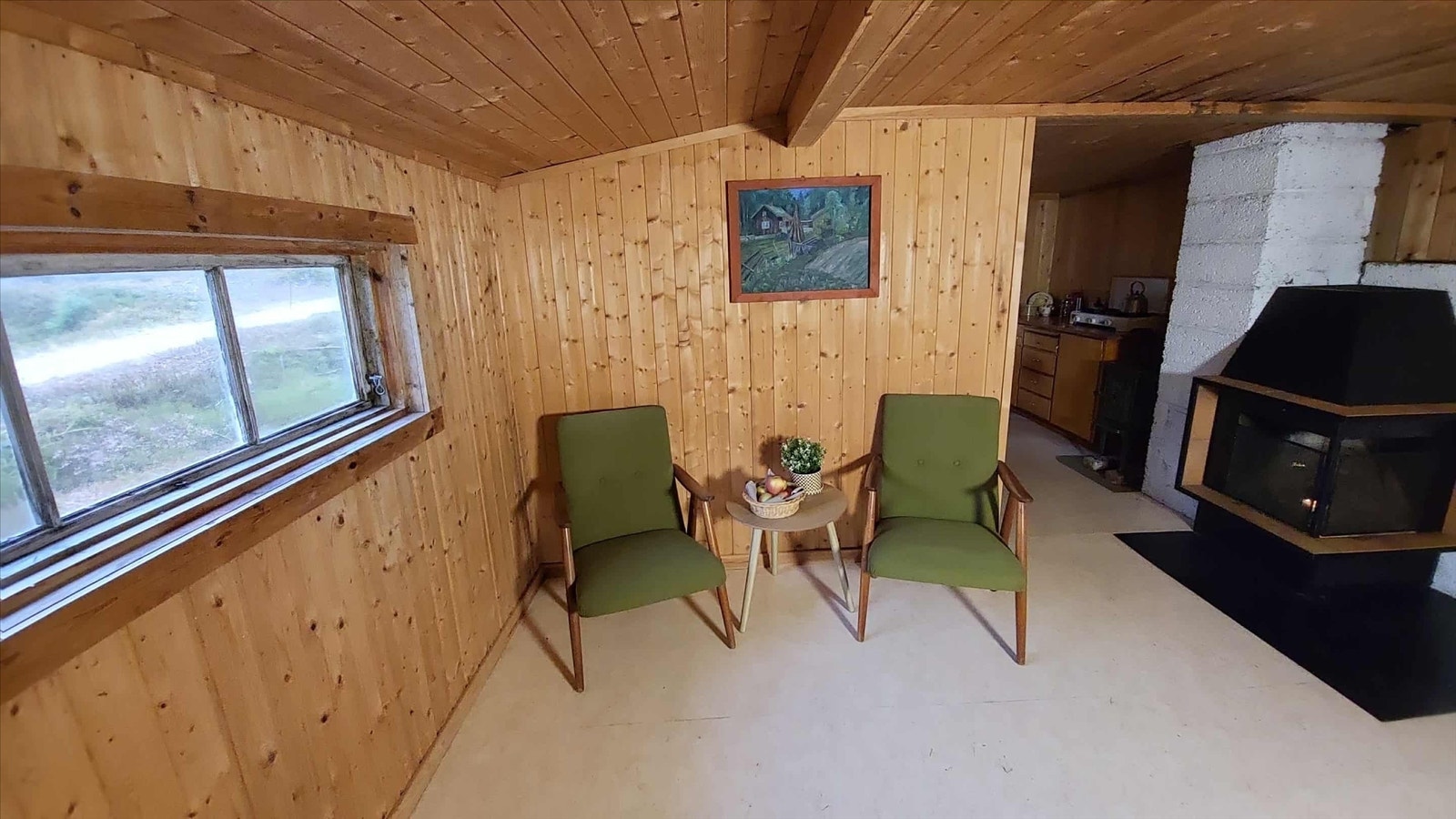 Innvendig er det en åpen løsning med stue og spisedel, kledd i ubehandlet panel. Galleribilde