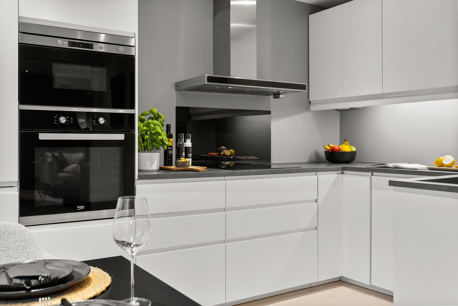 Veggmontert avtrekksventilator i børstet stål med kullfilter over koksesonen. Komfyrvakt er montert. Galleribilde