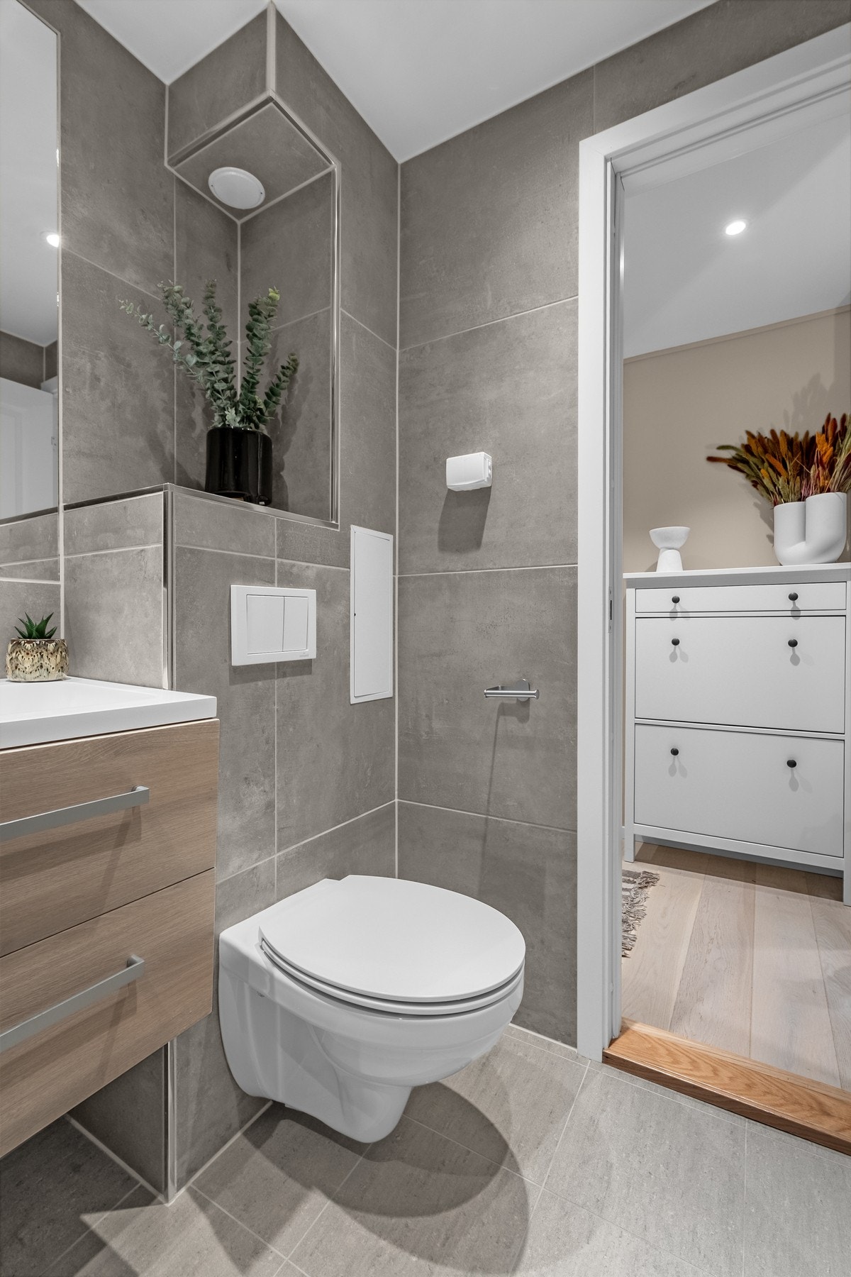 I gulvet er det varmekabler og innredningen ellers består av vegghengt toalett, dusjhjørne med innfellbare glassdører, regndusj og hånddusj. Det er også opplegg for vaskemaskin. Galleribilde