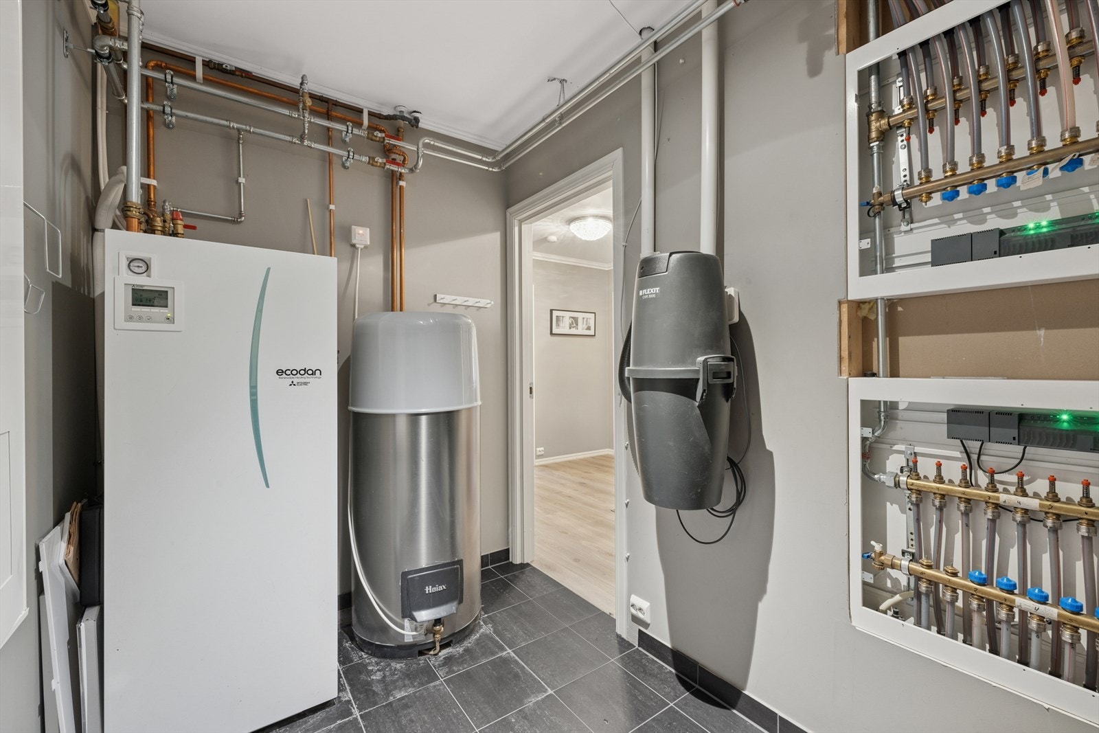 Teknisk rom med varmeveksler til vannbåren varme. Høiax varmtvannsbereder og sentralstøvsuger. Galleribilde