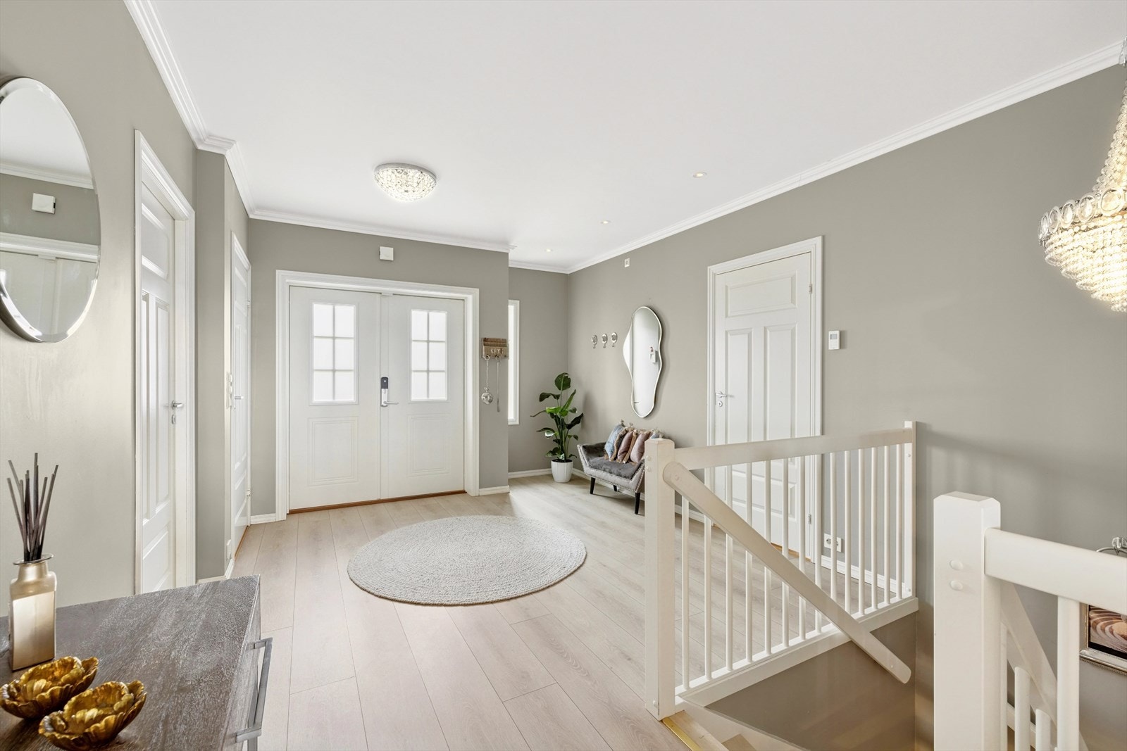 Man ønskes velkommen inn i den romslige hallen. Her er det pene laminatgulv og vegger er malt i en behagelig gråfarge. Galleribilde