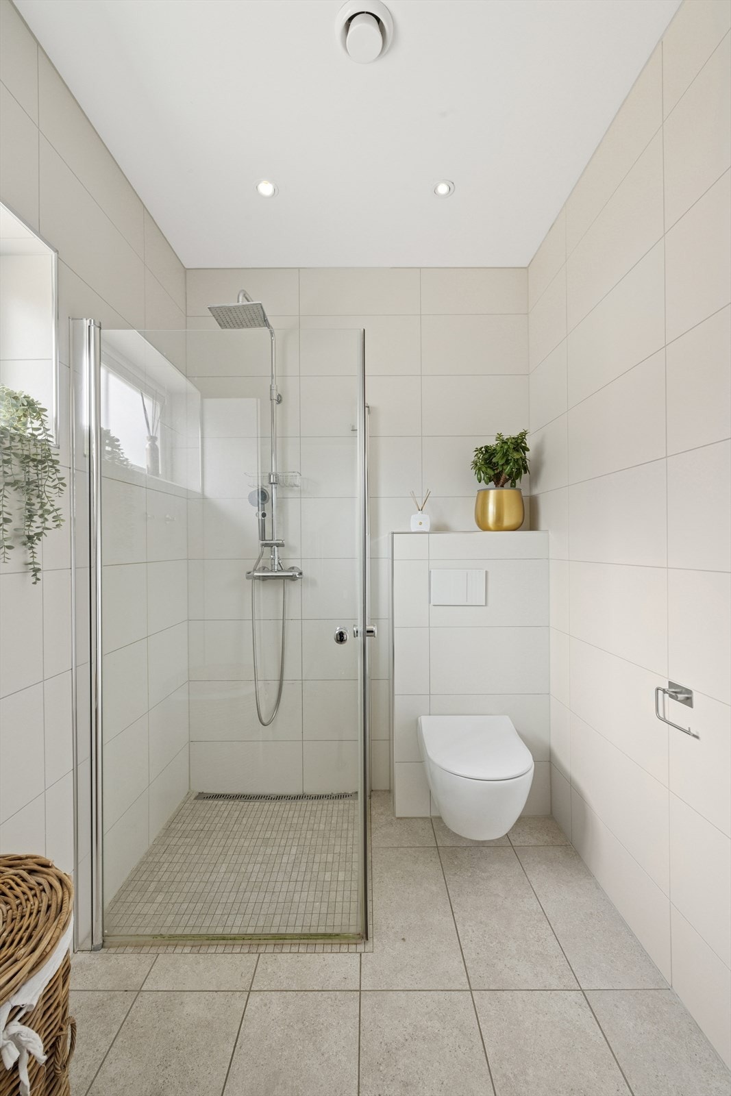 Det er varmekabel i gulvet og innfellbare dusjdører i herdet glass samt veggmontert toalett. Galleribilde