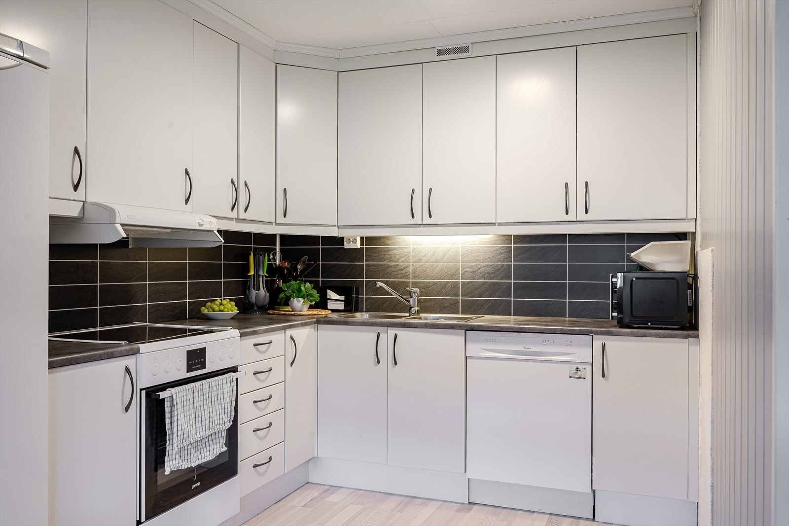 Lys og moderne kjøkkeninnredning fra 2007 med god skap- og benkeplass. Innredningen har hvite glatte fronter og laminert benkeplate med nedfelt oppvaskkum. Galleribilde