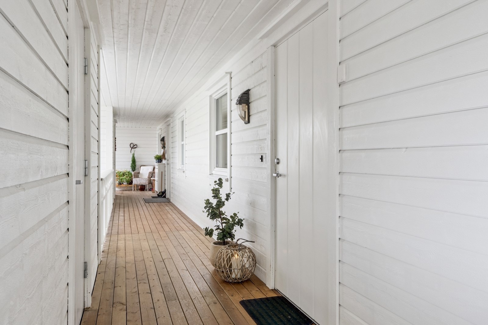 Overbygd svalgang med bod ved inngangsdør. Galleribilde