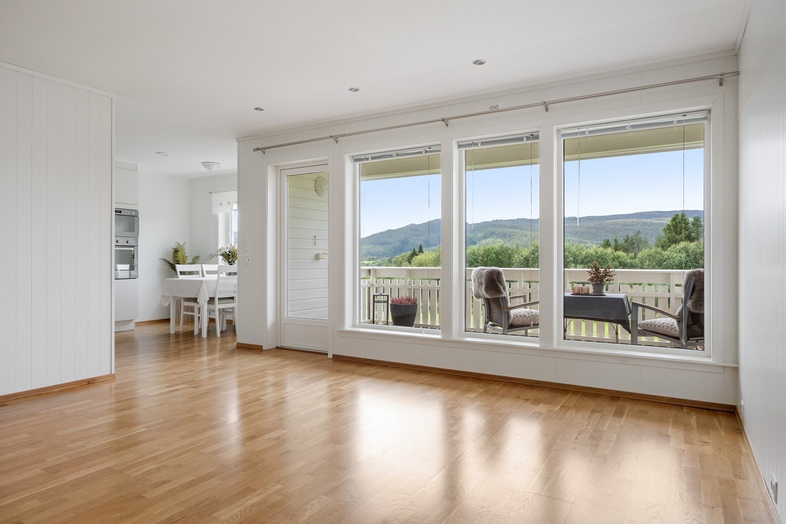 Åpen og lys stue med glassfasade i front. Galleribilde